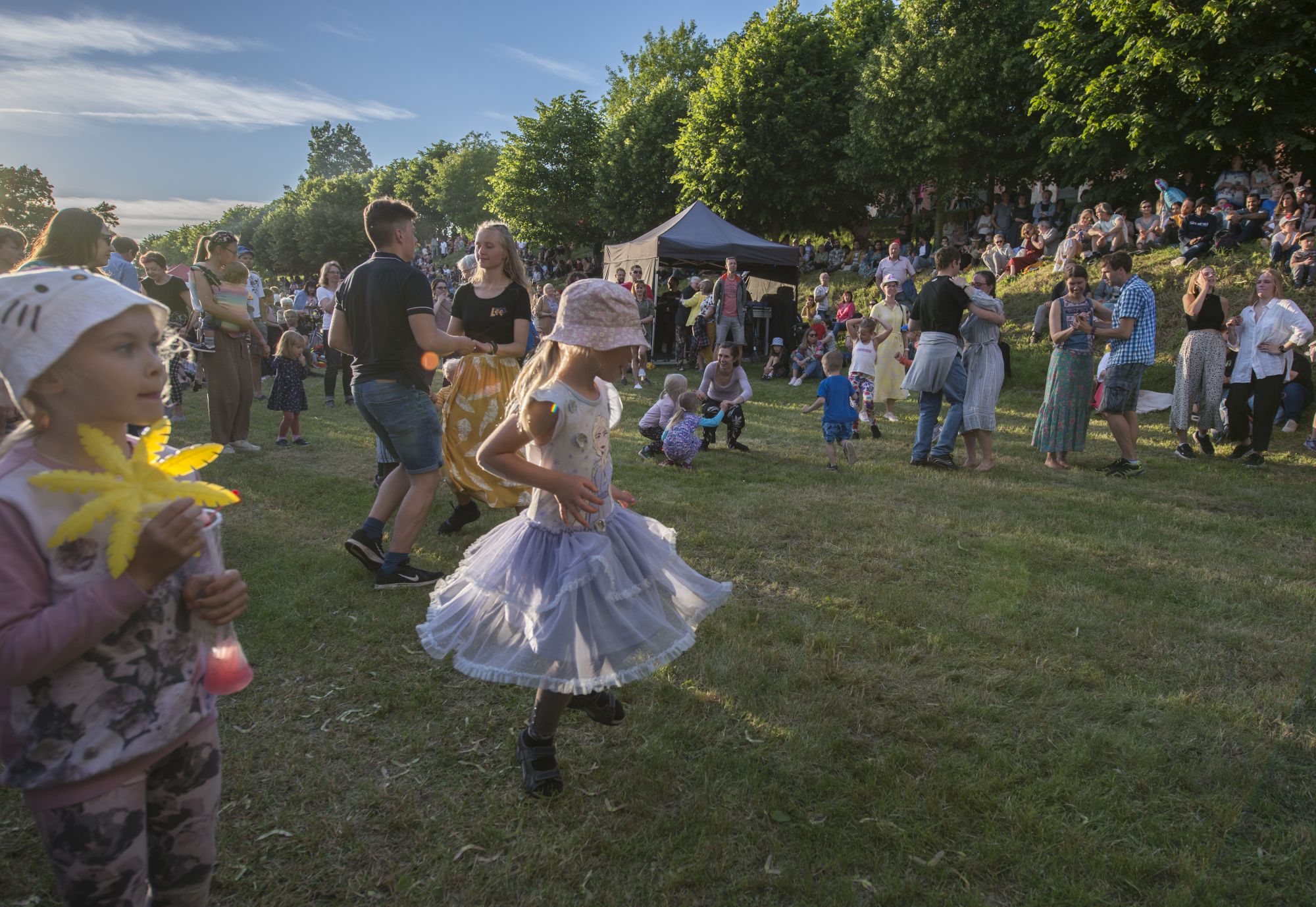 Foto suvisel peol tantsivatest inimestest, fookuses väike tüdruk.
